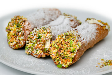 Cannoli siciliani ripieni di ricotta e pistacchi, dessert tradizionale italiano 
