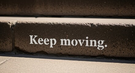 Inspirational message stenciled on urban steps encouraging progress and perseverance