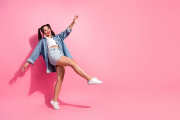 Young woman dancing in denim jacket and shorts pink background casual summer fashion joyful energy advertising fashion campaigns
