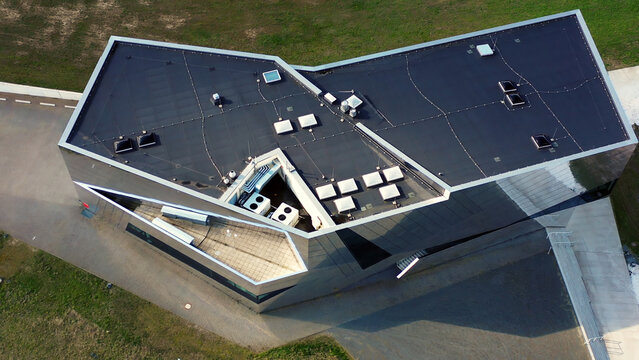 Modern building roof design featuring angular architecture and solar panels, viewed from above