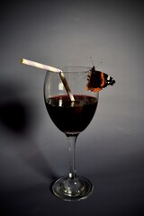 Schmetterling an Glas und Strohalm