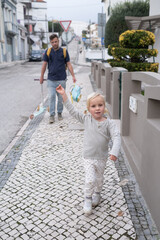 A 4 Year Old Girl Walking Home from Kindergarten with Her Dad Carrying Her Backpack and Scooter