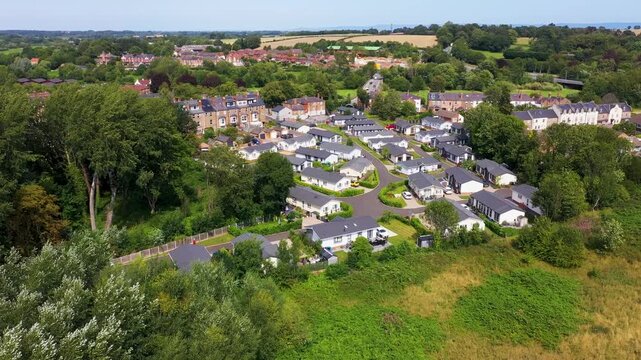 Aerial drone footage of the village of Ripon in North Yorkshire in the UK showing the historic British village and streets full of rows of terrace houses from above on a sunny day in the summer time