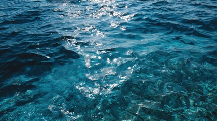 Naklejka premium Blue ocean water with sparkling sunlight reflections
