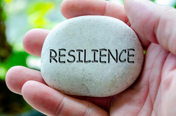 Resilience text engraved on white stone. Life harmony concept.