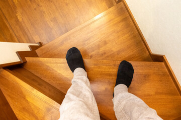 木製の階段の途中に立つ人物