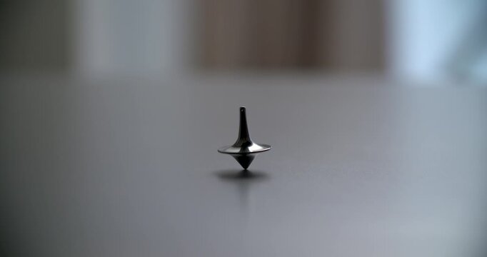 Black Spinning Top Gyro in Motion on White Surface