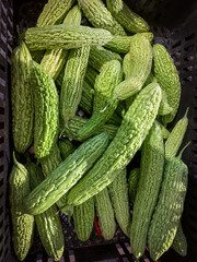 Fresh bitter melon on rustic surface, vibrant green texture highlighting natural health benefits, ideal for organic food concepts and wellness themes in modern culinary photography.