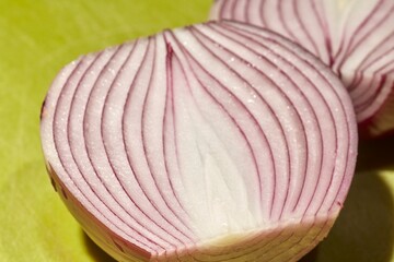 Slices of red onion, sometimes called "Bermuda onion" on a green plastic cutting board