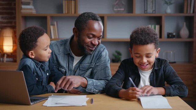 African American happy family father helping sons study education at home distant e-learning father with two boys kids children assistance with school homework teaching writing task with laptop talk