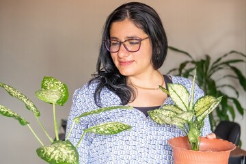 A woman is holding a plant in a pot