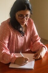 A woman is writing in a notebook