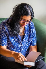 A woman is sitting on a couch reading a book