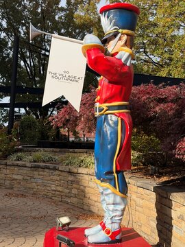 Colorful holiday bugler trumpeter soldier with a sign for The Village at SouthPark in Charlotte, NC