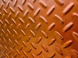 Close-up view of textured brown metal surface with raised oval patterns creating an industrial design