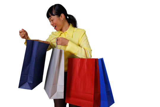 Woman happily looking into shopping bag, experiencing retail therapy with multiple colorful bags, transparent background