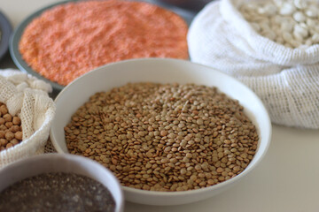 Bowls and bags full of various healthy grains and legumes. Selective focus.