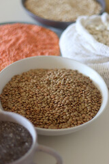 Bowls and bags full of various healthy grains and legumes. Selective focus.