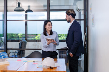 business manager colleague discuss budget topic in creative green office co-working space, team of business people coworker casual online meeting on tablet standing desk modern office workplace
