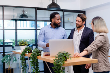 team of multiethnic colleague discuss business topic in creative green office co working space, group of business people coworker casual online meeting on tablet standing desk modern office workplace