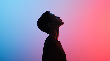 Silhouette of a figure illuminated by vibrant red and blue lighting. Head tilted back, the figure exudes a sense of peace and contemplation against a gradient backdrop.