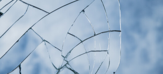 abstract wallpaper with shattered broken glass window or mirror shards reflecting the blue sky