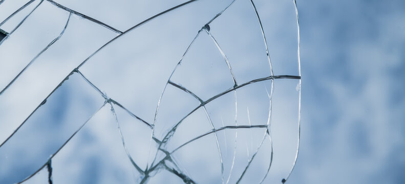 abstract wallpaper with shattered broken glass window or mirror shards reflecting the blue sky