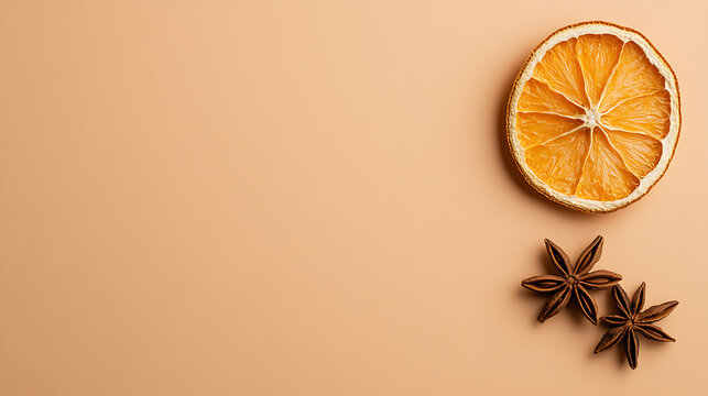 Minimalist studio shot featuring a dried citrus slice and two star anise on a warm tan backdrop, ideal for autumnal themes or culinary concepts with organic elements.