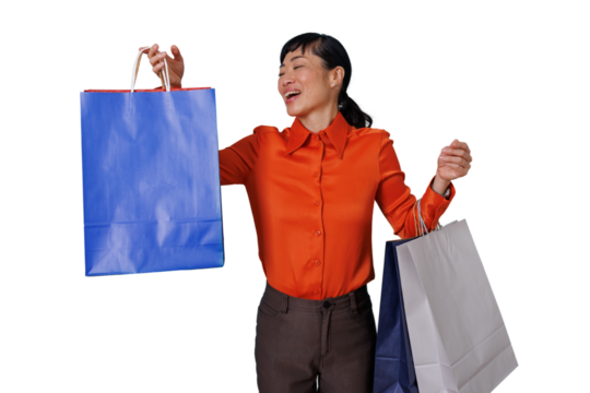 Happy asian woman celebrating success, embracing consumerism with colorful shopping bags, transparent background