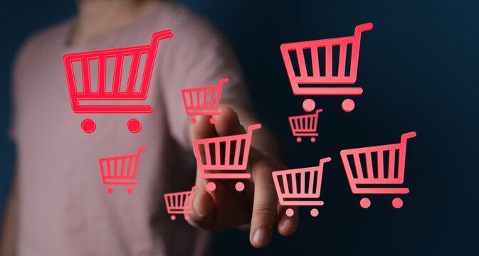 Hand reaching towards floating shopping cart icons representing digital commerce, online shopping, and consumerism. E-commerce and retail concep