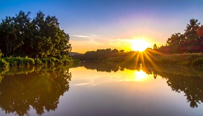Sunset over a serene river, reflecting the golden light, flanked by lush green trees under a vibrant blue sky