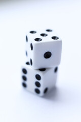 Two white dice with black dots on a white background. Close-up.
