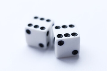 Two white dice with black dots on a white background. Close-up.