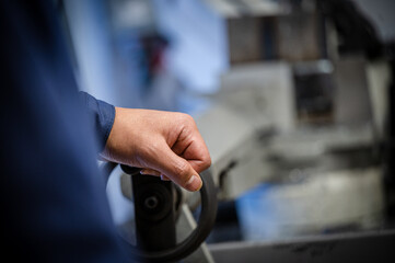 Worker operating machine handle in workshop