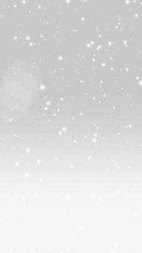 グレーのグラデーション背景に、降り積もる雪とキラキラ輝く光の縦長アニメーション。スキーやアイスフェスティバルなど、幻想的な冬の背景に最適。