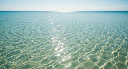 Crystal Clear Tropical Ocean Water with Sparkling Sun Reflections and Sandy Bottom