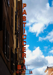 Colorful Italian pasticceria sign against blue sky