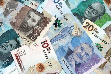 Colombian pesos money bills banknotes lies in big pile on table close up. Concept of finances and business in Colombia