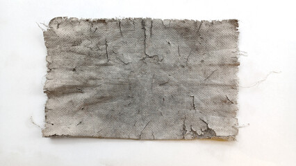Close-up of a ripped, dirty, and worn piece of fabric or canvas with cracked texture, isolated on a white background. Excellent for grunge, decay, vintage, industrial, horror, and abstract background 