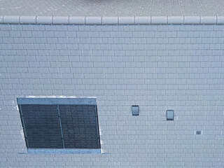 Drone inspection view of a newly fitted roof and solar panel to a new build house in the UK. Note the two air ducts.