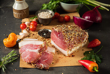 Cured meats are beautifully sliced and paired with colorful vegetables in a cozy kitchen setting