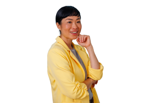 Asian woman in a yellow blazer thinking and smiling, looking away with hand on chin, contemplating new ideas