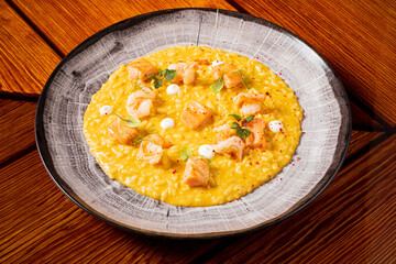 A rich dish of shrimp risotto garnished with herbs and drizzled with sauce invites indulgence