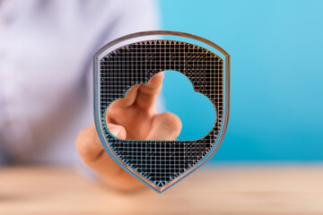 Hand pointing towards cloud data security shield concept on blue background. Illustrative technology related di