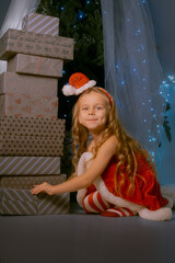 Christmas magic moment with a woman in red Santa dress sitting by a huge tower of holiday gifts.