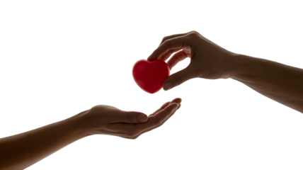 Generous hand offers red heart symbol to open palm, conveying compassion, love, and selfless giving in a moment of connection