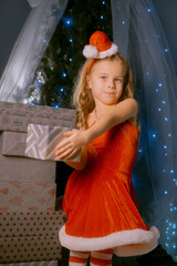 Elegant young woman dressed as Santa Claus enjoying the festive season next to a decorated Christmas tree.