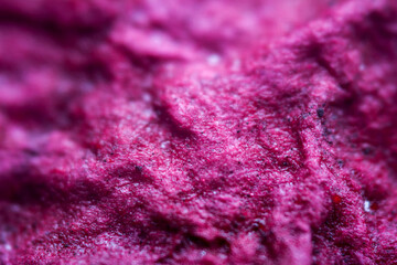 Extreme close up of purple handmade paper clay with a structure and rough texture. Paper recycling. Selective soft focus, shallow depth of field.