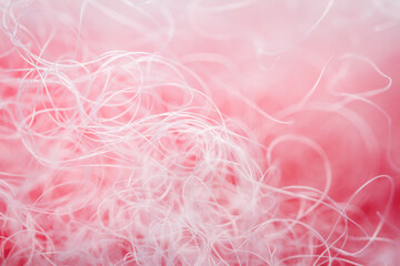 Extreme macro of polyester stable fiber on red background. Selective focus, shallow depth of field. Abstract dreamy background