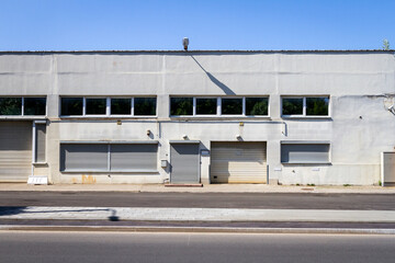 Detail of a old industrial building with doors, gates and windows.